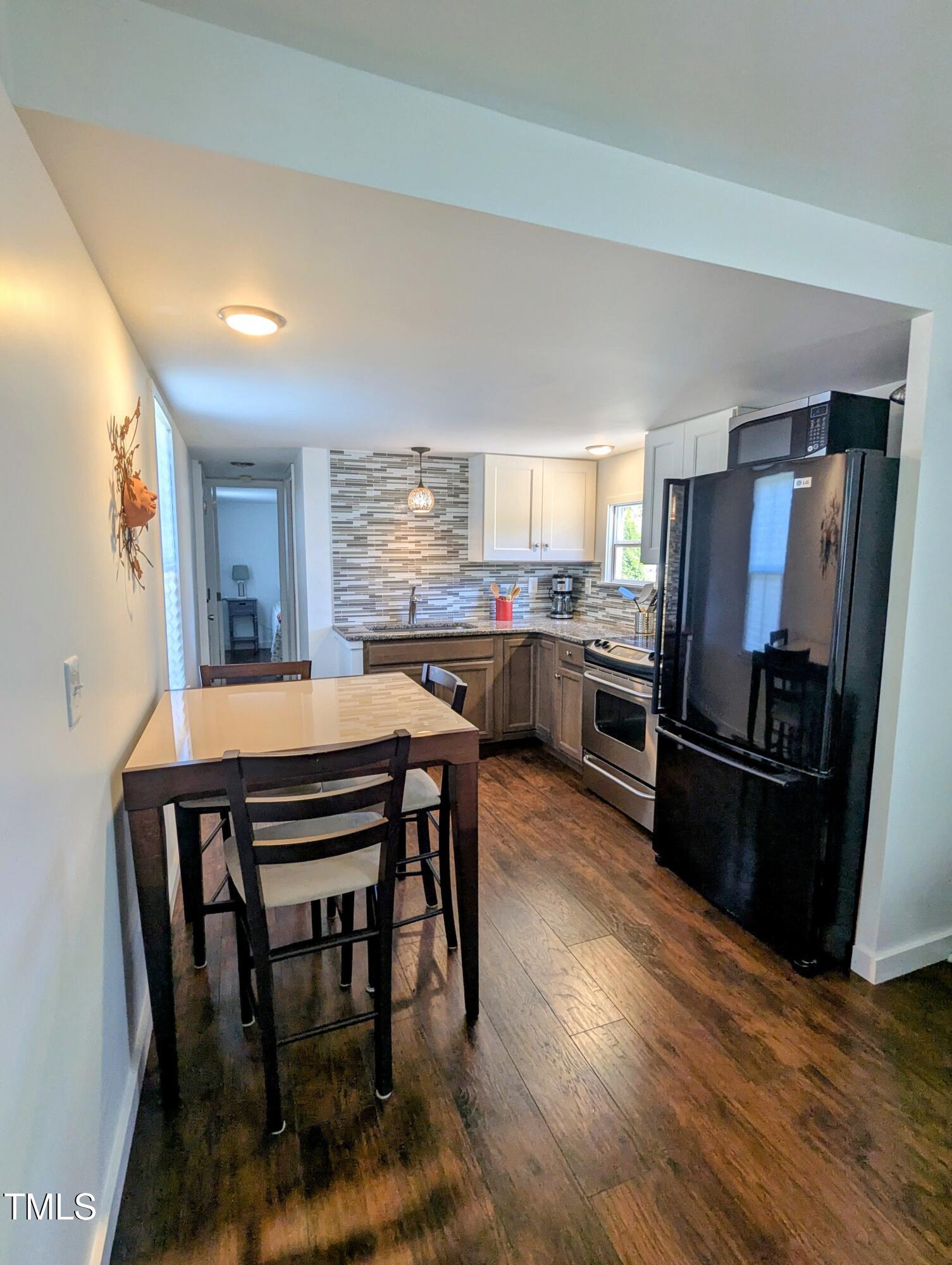 529 Flanagan Road Henderson, NC 27537 - Photo 17 of 38 a kitchen with stainless steel appliances wooden floor dining table and chairs