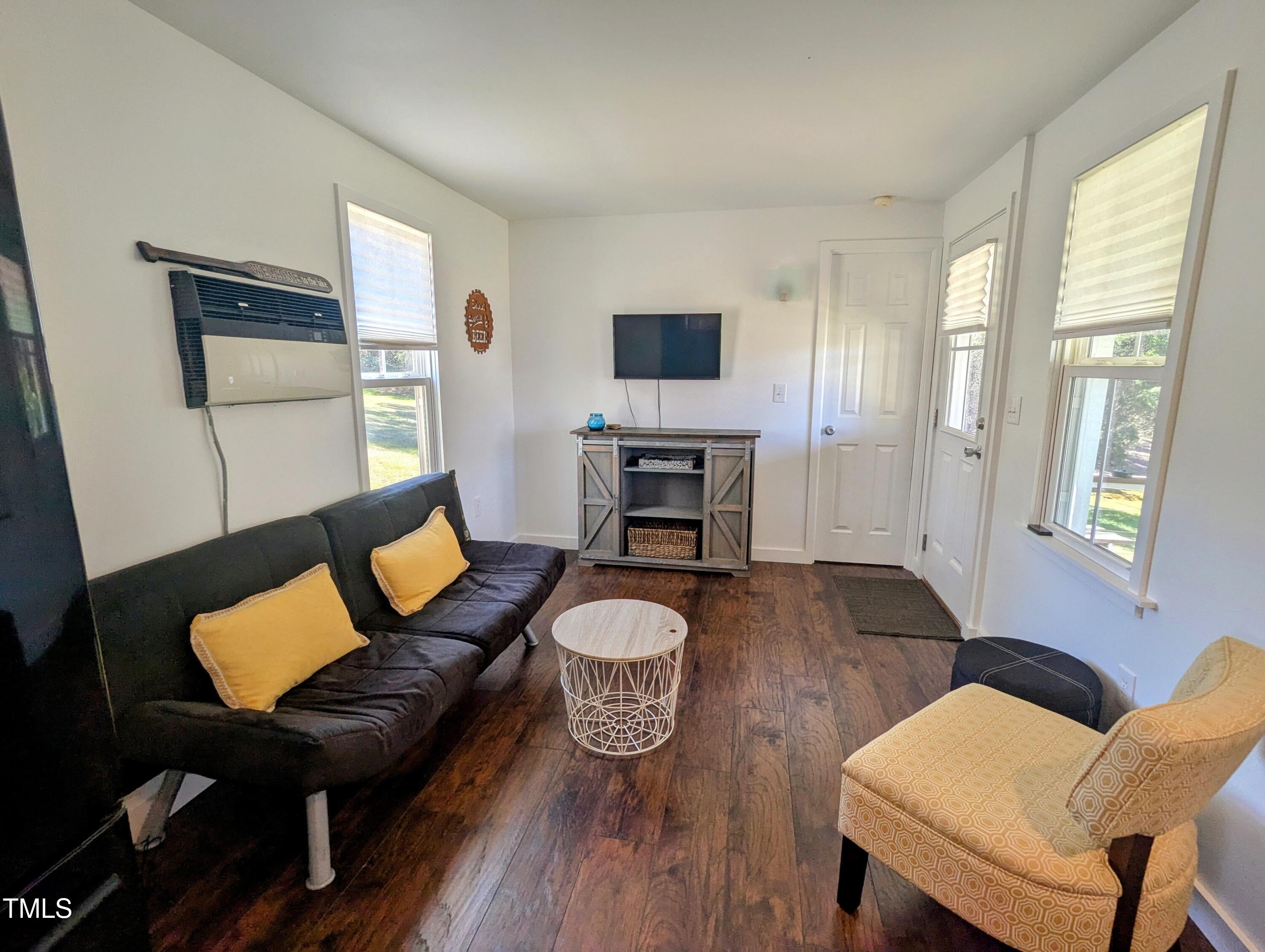529 Flanagan Road Henderson, NC 27537 - Photo 9 of 38 a living room with furniture a table and wooden floor