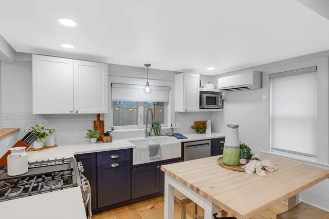 a kitchen with a refrigerator a stove a sink dishwasher and white cabinets with wooden floor