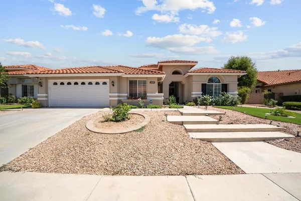 a view of a white house with a swimming pool and a chairs