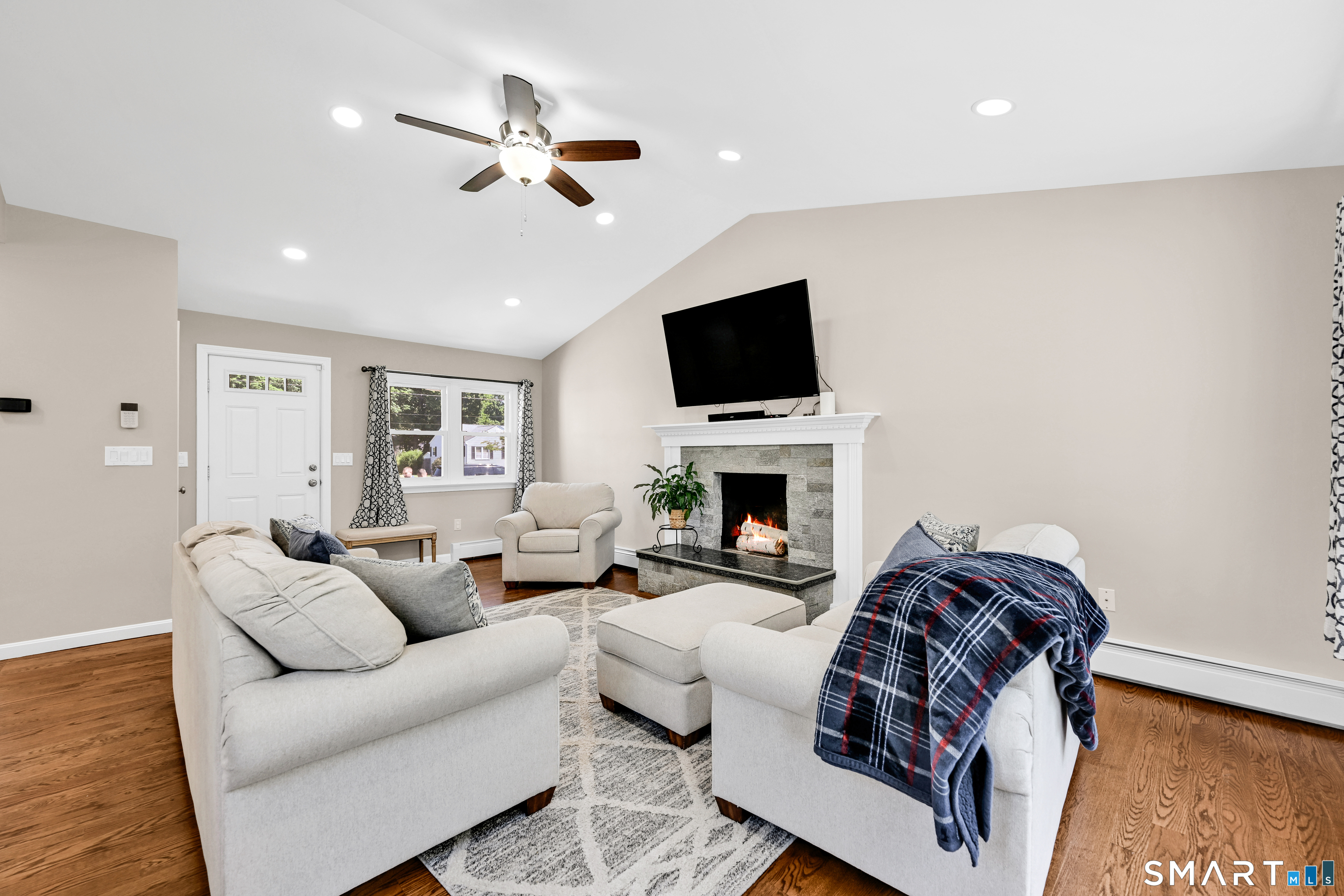 87 Lydall Road Newington, CT 06111 - Photo 8 of 35 a living room with furniture a fireplace and a flat screen tv