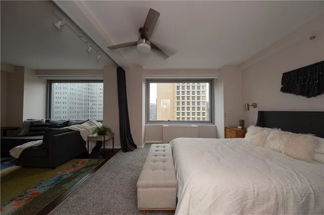 a bedroom with a bed a couch and a flat tv screen