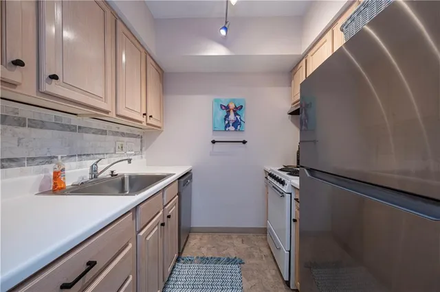 a kitchen with stainless steel appliances a sink stove and cabinets
