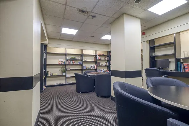 a living room with furniture a large window and chandelier