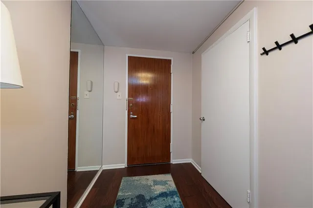 a view of hallway with closet and wooden floor