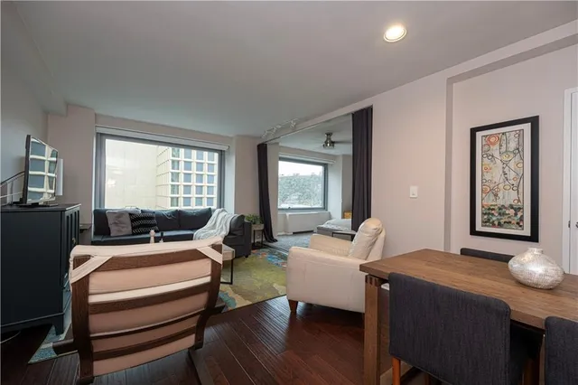 a living room with furniture two night stand and a window