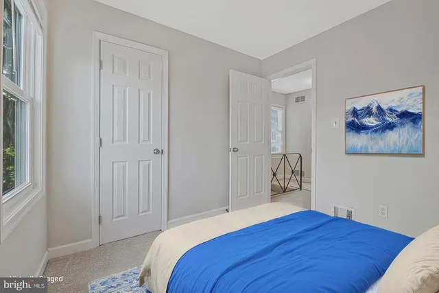 a bedroom with a bed and a painting on the wall