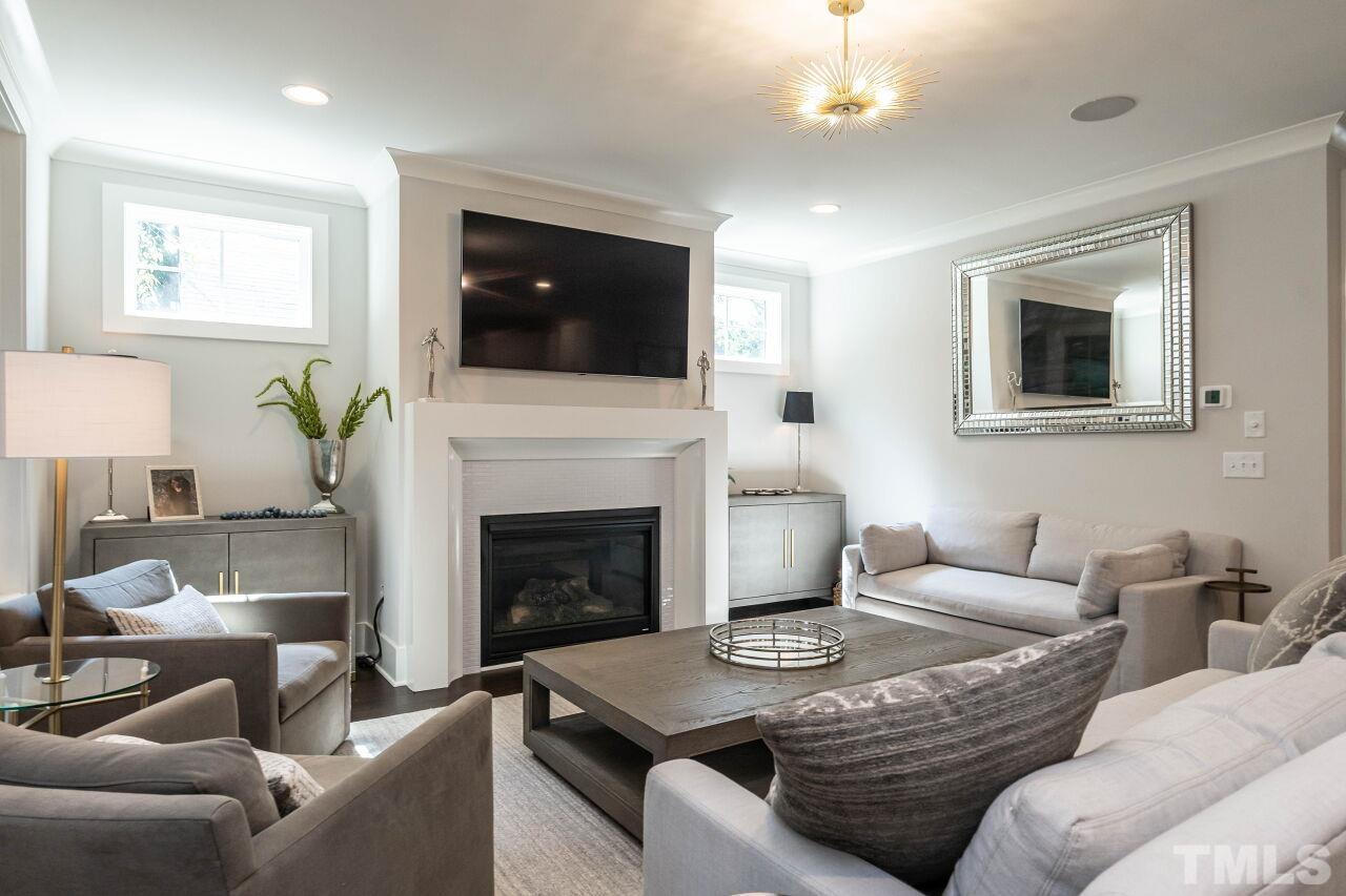 731 New Raleigh, NC 27608 - Photo 8 of 28 a living room with furniture a flat screen tv and a fireplace