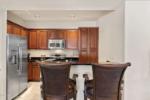 a kitchen with granite countertop a sink and refrigerator