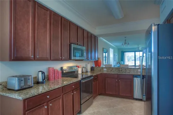 a kitchen with granite countertop wooden cabinets stainless steel appliances a sink and dishwasher
