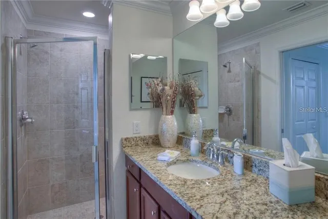 a bathroom with a granite countertop sink a toilet and shower