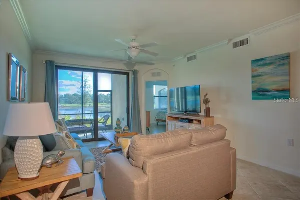 a living room with furniture and floor to ceiling window