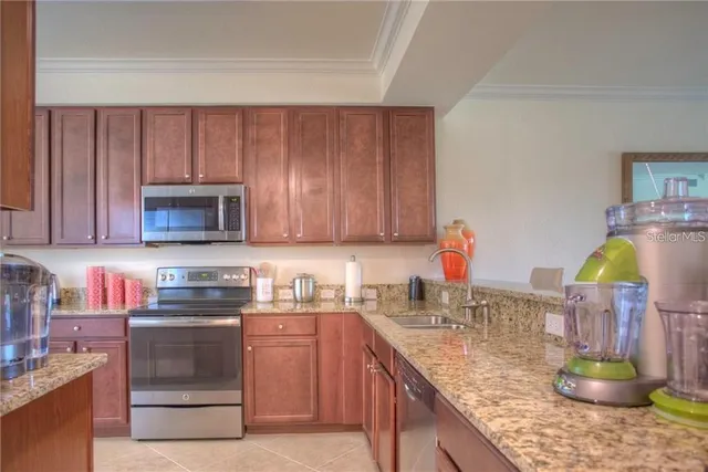 a kitchen with stainless steel appliances granite countertop a sink stove and cabinets