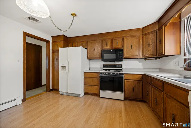 a kitchen with stainless steel appliances granite countertop a stove a refrigerator and a microwave