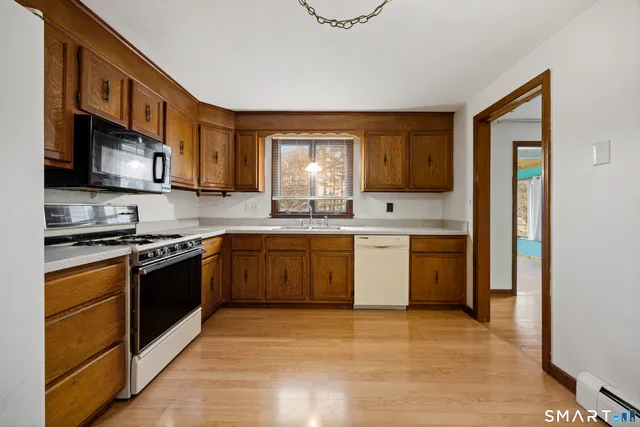 a kitchen with stainless steel appliances granite countertop a stove a sink and a microwave