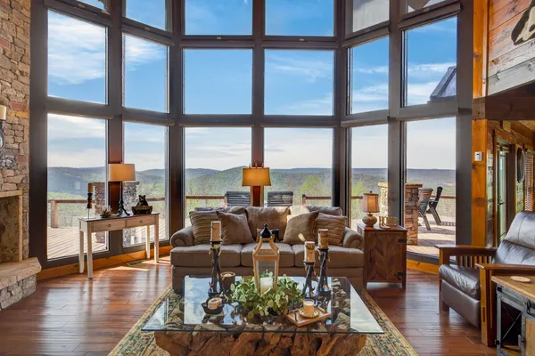 a living room with furniture and floor to ceiling windows