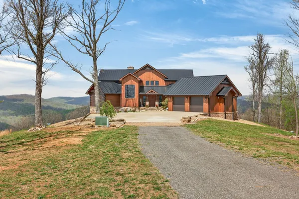 a front view of a house with a yard covered with snow and trees