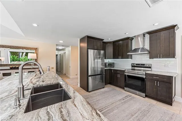 a kitchen with stainless steel appliances granite countertop a refrigerator stove and sink