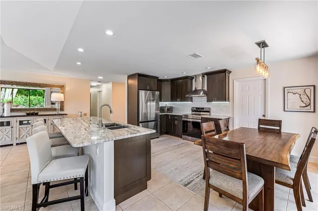 a view of kitchen with microwave stove refrigerator dining table and chairs