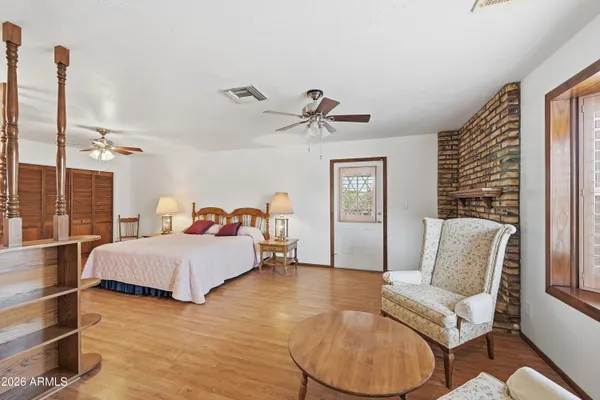 a bedroom with a bed couch and a ceiling fan