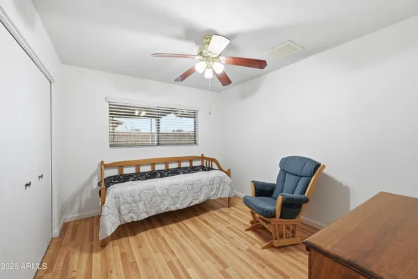 a view of a livingroom with a chandelier fan and wooden floor
