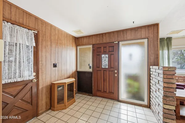 a living room with stainless steel appliances furniture a chandelier a rug and a window
