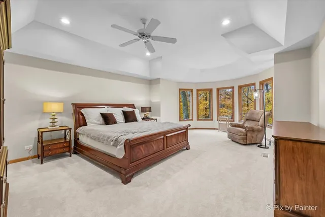 a spacious bedroom with a bed a couch and large window