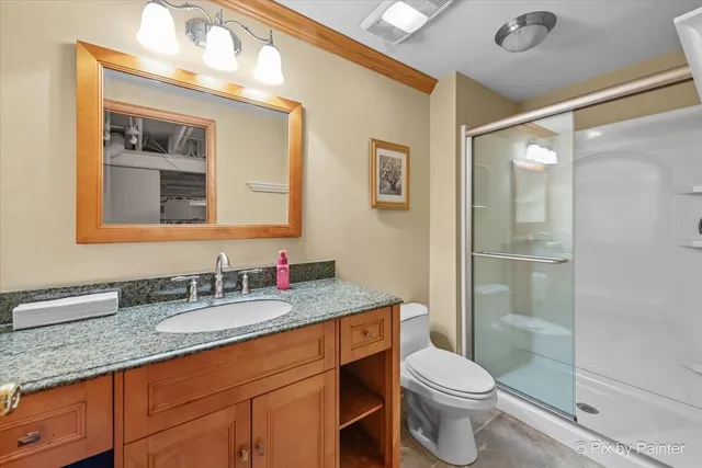 a bathroom with a granite countertop sink mirror vanity and toilet