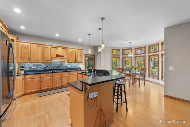 a kitchen with stainless steel appliances granite countertop sink stove and refrigerator