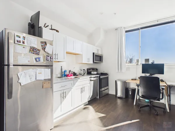 a kitchen with refrigerator cabinets and wooden floor