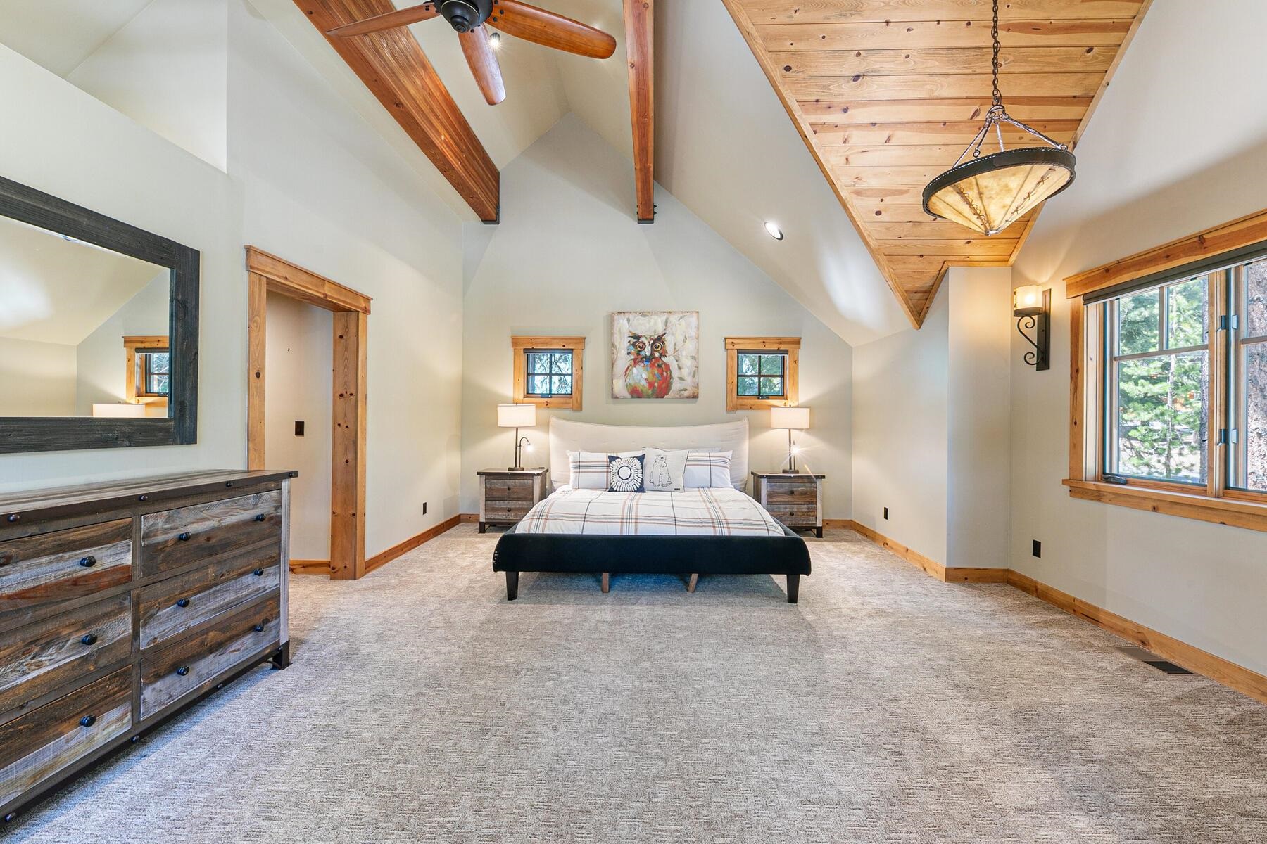 12326 Greenleaf Way Truckee, CA 96161 - Photo 24 of 28 a spacious bedroom with a bed a couch and a flat tv screen on dresser