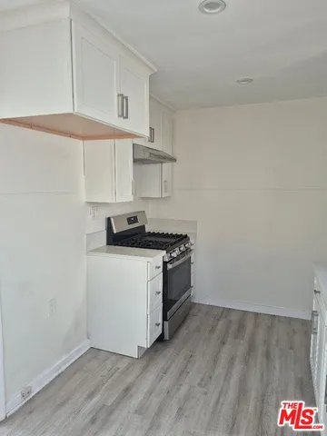 a kitchen with granite countertop a stove and a wooden cabinets