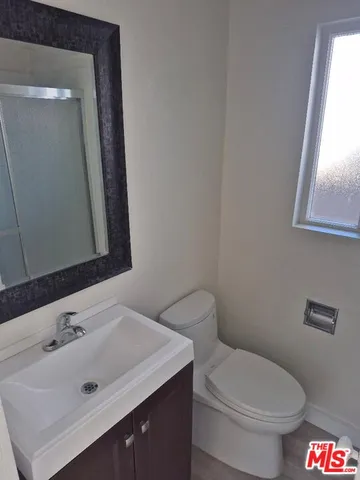 a bathroom with a sink mirror and toilet