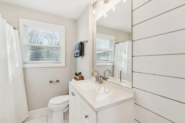 a bathroom with a sink toilet and window