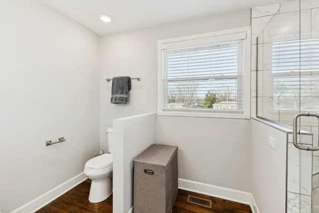 a bathroom with a toilet and a window
