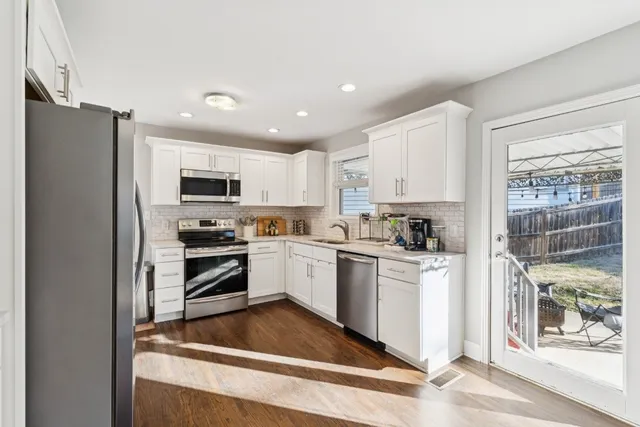 a kitchen with white cabinets and stainless steel appliances