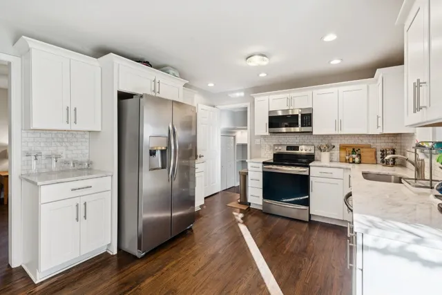 a kitchen with a refrigerator a stove top oven a sink and cabinets