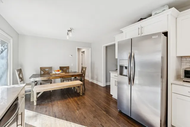 a living room with stainless steel appliances furniture a counter top space and a view of kitchen