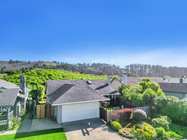 a view of a house with a yard and a garden