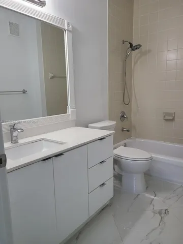 a bathroom with a sink toilet vanity and shower