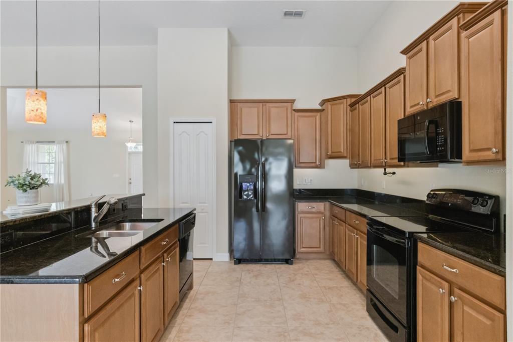 5832 Tarleton Way Mount Dora, FL 32757 - Photo 11 of 31 a kitchen with stainless steel appliances granite countertop a sink stove and refrigerator