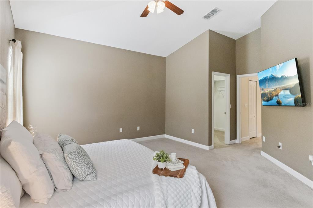 5832 Tarleton Way Mount Dora, FL 32757 - Photo 16 of 31 a bedroom with a bed and a painting on the wall