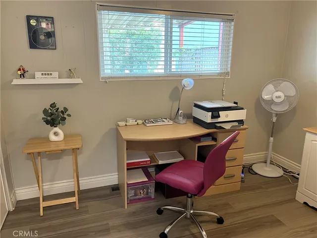a view of a workspace with furniture and a window
