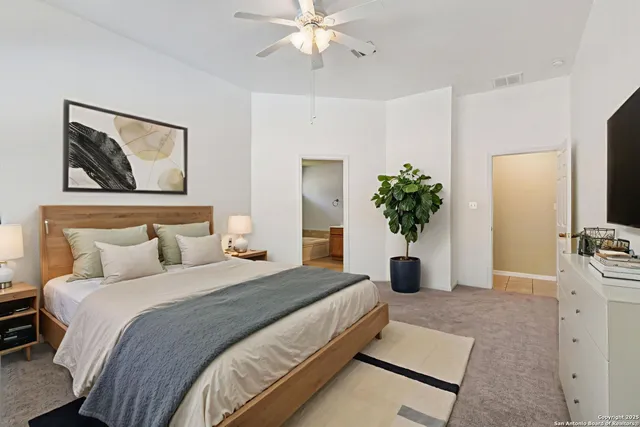 a bedroom with a large bed and a chandelier