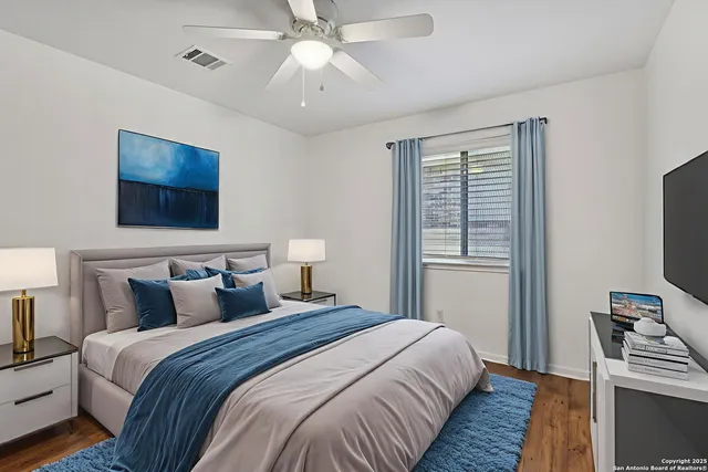 a bedroom with bed tv and a window