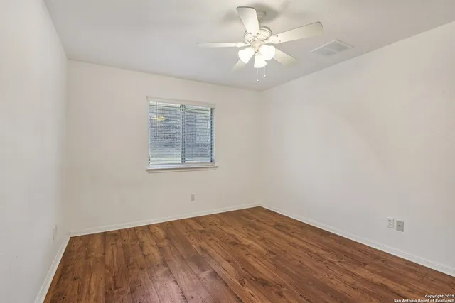 an empty room with wooden floor and window