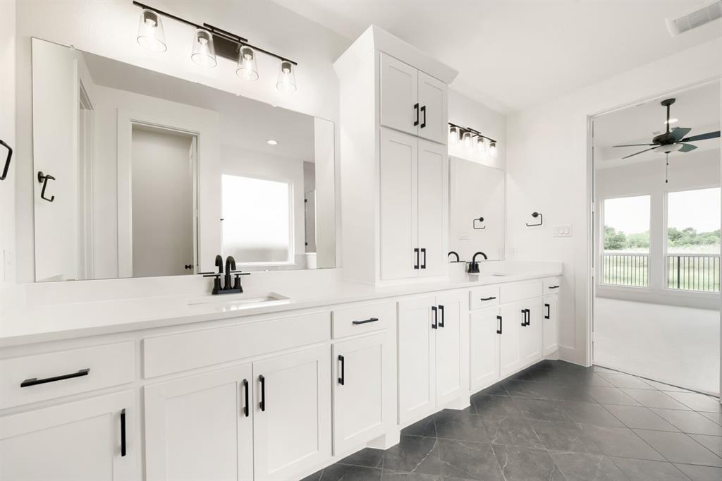 733 Red Cedar Road Haslet, TX 76052 - Photo 22 of 28 Dual vanity with white cabinetry, matte black hardware, and quartz countertops