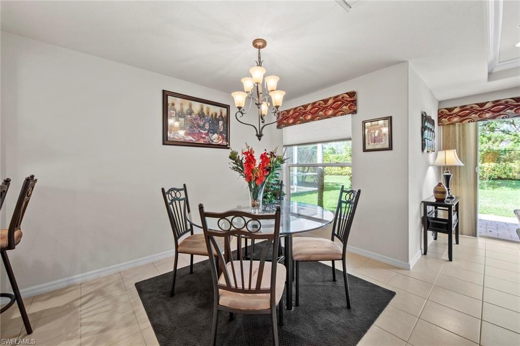9046 Astonia Way Estero, FL 33967 - Photo 17 of 47 a view of a dining room with furniture a chandelier and wooden floor