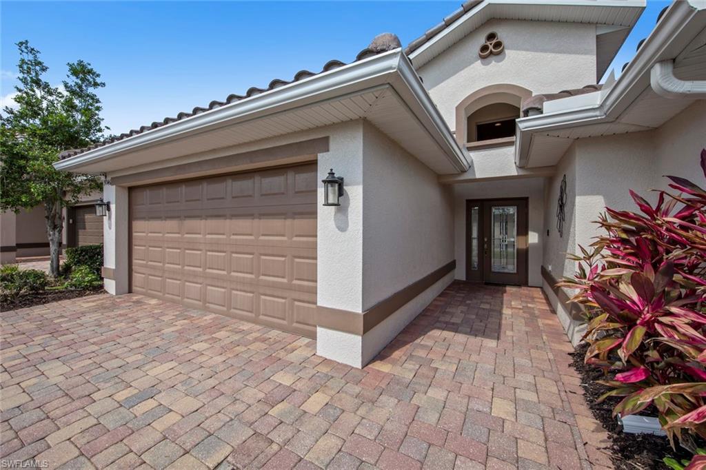 9046 Astonia Way Estero, FL 33967 - Photo 2 of 47 a view of white house with a small yard and plants