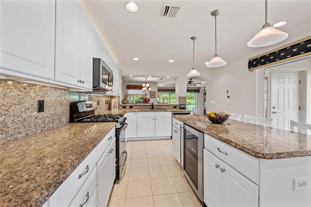 9046 Astonia Way Estero, FL 33967 - Photo 22 of 47 a kitchen with stainless steel appliances granite countertop a sink a stove and a wooden cabinets